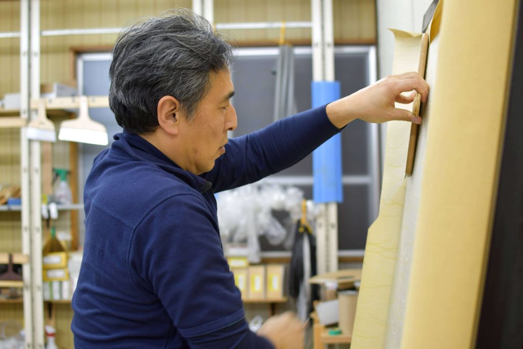 金沢屋日本平店の職人がふすまを張り替えている画像です