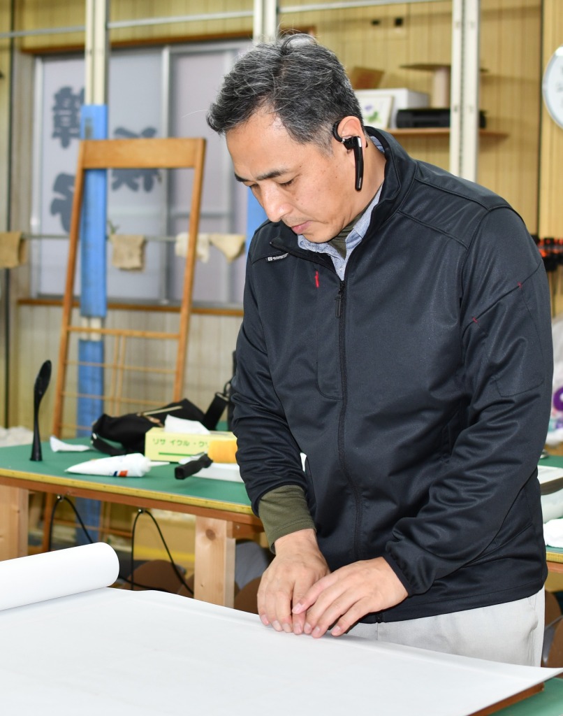 障子を張り替えている職人の画像